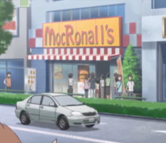 A building with a red and yellow sign on it, reading 'MocRonall's.